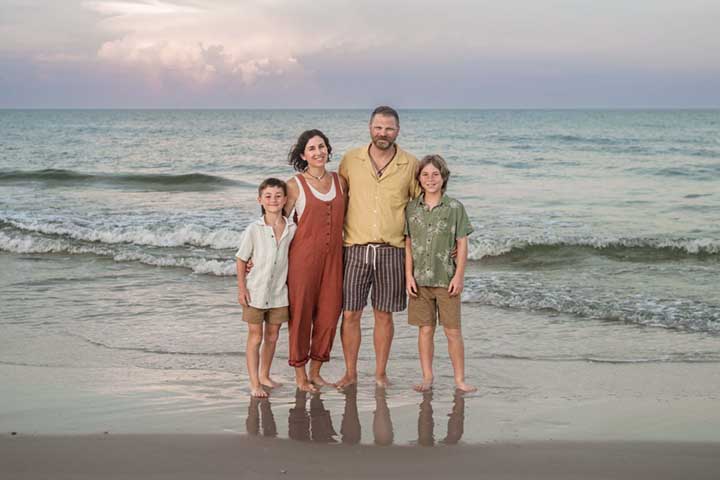 Cape San Blas family portrait session at sunrise with family of four standing in the waves by Aimee V Photography